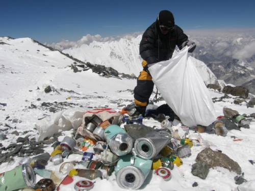 A Nepalese sherpa collecting garbage, left by climbers, at an altitude of 8,000 metres during the Everest clean-up expedition at Mount Everest. (Getty)