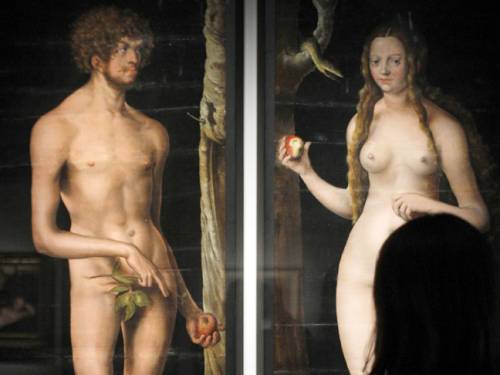 A woman looks at a painting entitled 'Adam and Eve' (1508-1510) by German artist Lucas Cranach the Elder. (AAP)