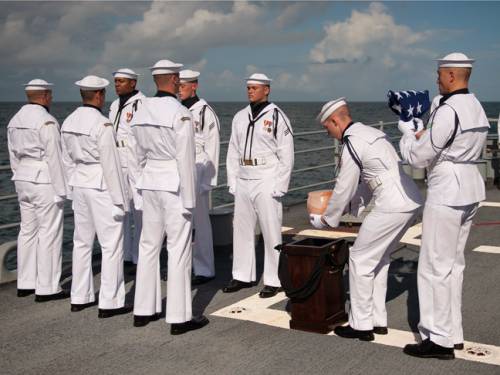 US Navy personnel carry the remains of Apollo 11 astronaut Neil Armstrong during a burial at sea service. (AAP)