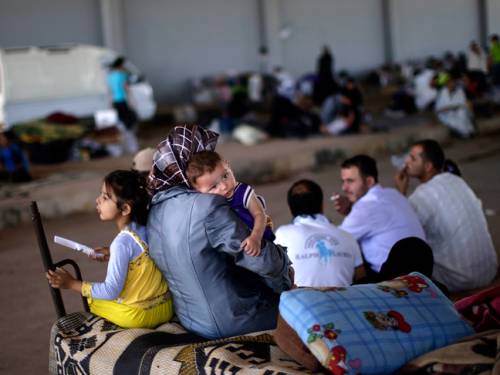 Syrians, who fled their homes due to fighting between the Syrian army and the rebels, take refuge at the Bab Al-Salameh border crossing. (AAP)