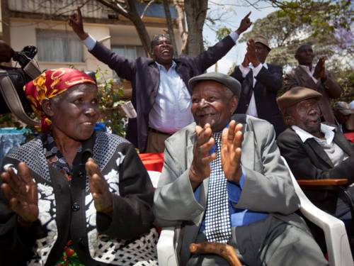 Kenyans Jane Muthoni Mara (l), Wambuga Wa Nyingi, and Paulo Muoka Nzili, celebrate the announcement of a legal decision in their case at Britain's High Court concerning Mau Mau veterans. (AAP)
