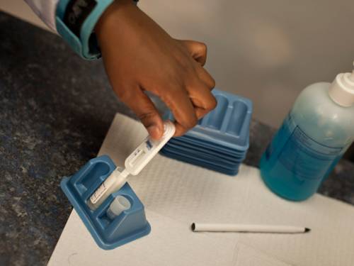 A client places an oral swab, similar to the take-home test, to complete an HIV test during a free HIV testing event. (FILE: GETTY)