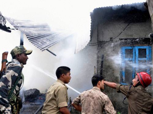 Indian fire fighters try to extinguish fire at a house following ethnic clashes in Kokrajhar, Assam state, India. (AP)