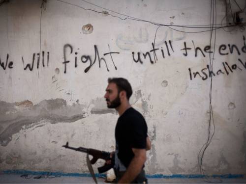 A Free Syrian Army fighter walks through a street in Amariya district in Aleppo, Syria.