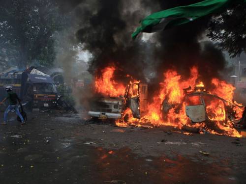 A rally by thousands of Muslims in Mumbai to protest over the unrest in Assam turned violent with three TV broadcast vans set on fire. (Getty Images)