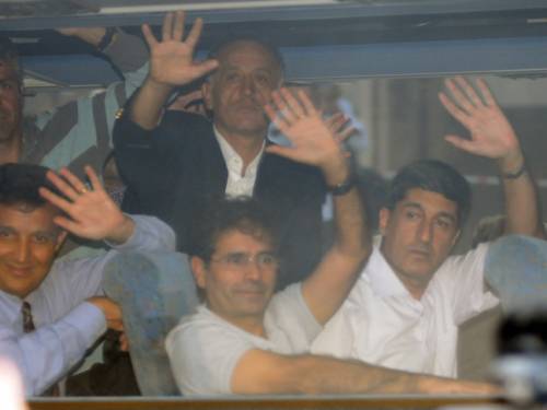 Accused army officers wave to family members waiting for the verdicts outside the court as they arrive in Silivri, some 60 kilometers from Istanbul. (AAP)