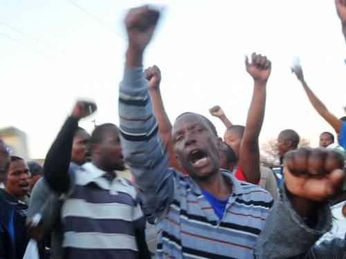 The freed workers sang and danced as they left the court while 10 minibuses readied to take them back to Marikana. (Getty)