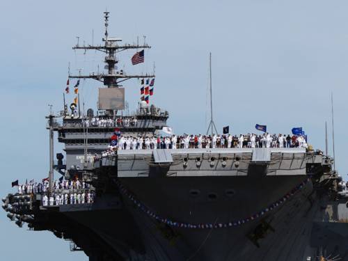 The crew of the USS (United States Ship) Enterprise lines the flight deck. (Getty)
