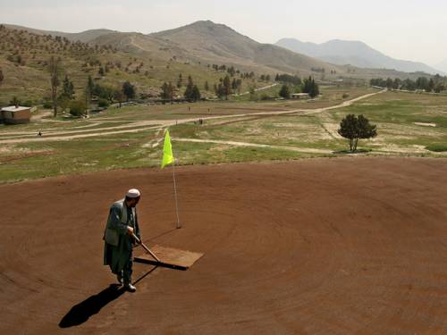 Sayed Marai sweeps the green on Kabul Golf Course, in Kabul, Afghanistan. The club was abandoned after the Soviets invaded the country in 1979, when most Western embassies evacuated their staff, later the Taliban declared golf un-Islamic and shut the course.