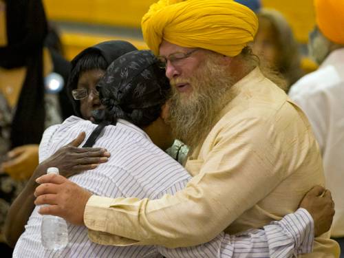 Mourners console one another at the funeral and memorial service for the six victims of the Sikh temple of Wisconsin mass shooting. (AAP)