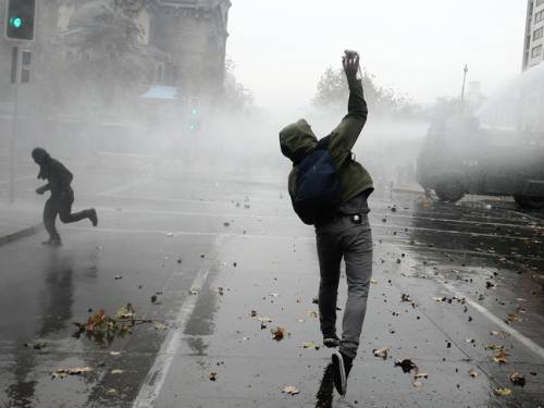 Anti-Pinochet demonstrators are dispersed by a riot police water cannon in front of the Caupolican Theatre in Santiago, Chile. (Getty)