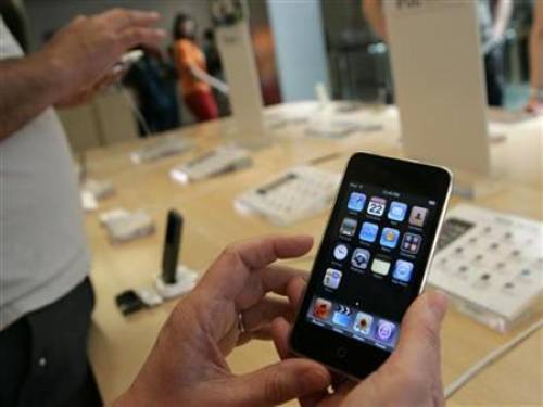 Customers look over an Apple iTouch at the company's retail store in San Francisco, California April 22, 2009. REUTERS/Robert Galbraith