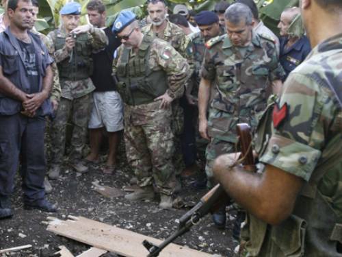 Lebanese and UN peacekeeping troops soldiers inspect the area where two rockets were fired into Israel (AAP).