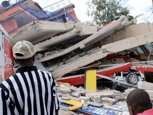 People look at the remains of a six-story communications building in Port-au-Prince, Haiti. (Getty Images)