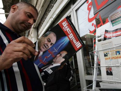 A man reads a magazine with Allawi on the cover (left). (EPA)