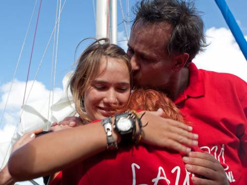 Teen sailor Laura Dekker embraces her sister Kim as her father Dick kisses her. (AP Photo)