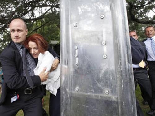 Ms Gillard stumbled as she was escorted by security guards. (AAP)