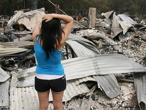A Bendigo resident inspects the remains of her home, destroyed by bushfires (AAP)