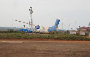 Kigoma airport - one that didn't make it. I was told this was a successful crash because no lives were lost. An airport worker told me the wreck remains not as a testament to safety, but because it was too costly to remove. The terminal is at the right. (SBS)