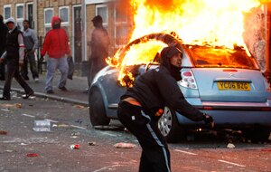 Rioters in London set fire to cars and throw rocks at police. (AAP)