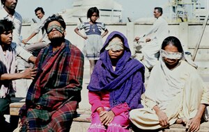 Victims who lost their eyesight after the 1984 poison gas leak from the pesticides plant in Bhopal, India, sit in front of the US Union Carbide factory (AFP/Getty Images)