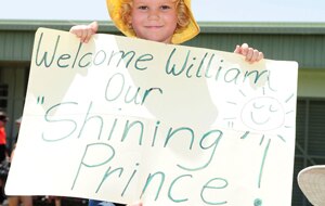 Jane Machan holds up a sign while waiting for Prince William at the Cardwel Community Hall on March 19, 2011. (Getty)
