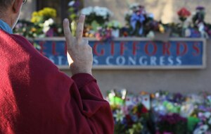 Dave Locke gestures as he looks over a memorial at the office of US Rep Gabrielle Giffords during a national moment of silence after the shooting. (Getty Images)