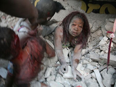 People carry the bosy of a victim of the Haiti quake (AFP)